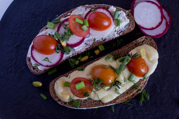Multigrain toast bread with melt gouda or kaseri cheese and small tomatoes radish and green onion on top