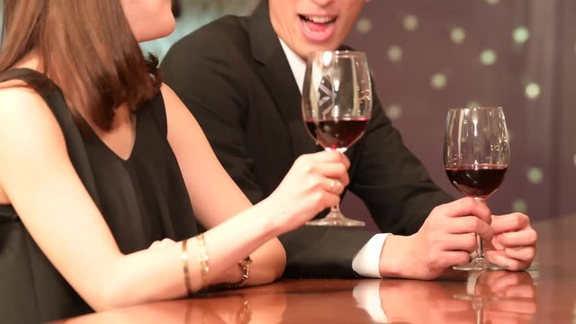 バーでワインを飲みながら談笑をするカップル