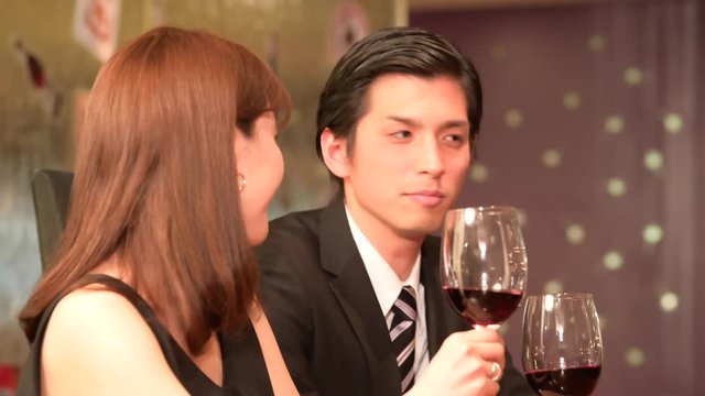 レストランでワインを飲みながら会話をするカップル