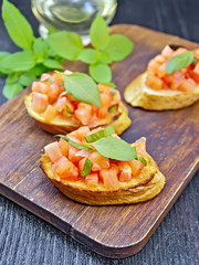 Bruschetta with tomato and basil on black board