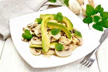 Salad of avocado and champignons on light table