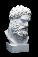 Bust of the Farnese Hercules. Heracles head sculpture, plaster copy of a marble statue isolated on black. Son of Zeus, the ancient Greek god. Ancient statue of hero
