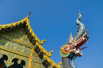Fototapeta na wymiar The Blue Temple or Wat Rong Sua Ten temple with blue sky background, Chiang Rai Province, Thailand. Beautiful blue naga sculpture in front of chapel of the blue temple with blue sky background.