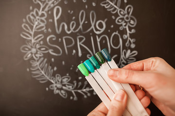 Nail designs in beautiful spring green tones, against the background of the inscription about spring