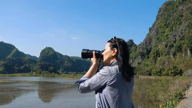 Attractive woman taking pictures of beautiful views at wetlands in Vietnam.