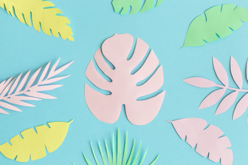 Fototapeta na wymiar Colorful tropical leaves made of paper against blue background minimal creative summer concept.