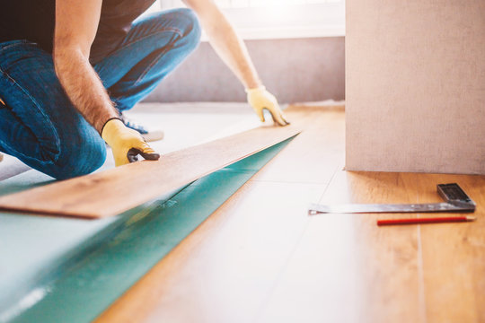 Man at home laying laminate flooring - finishing
