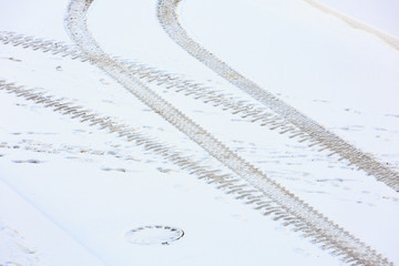 Traces of the tractor on the snow-covered road. View from above.