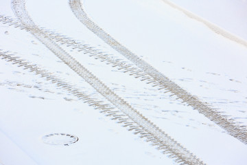 Traces of the tractor on the snow-covered road. View from above.