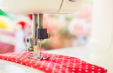 Close up of sewing machine working with red fabric