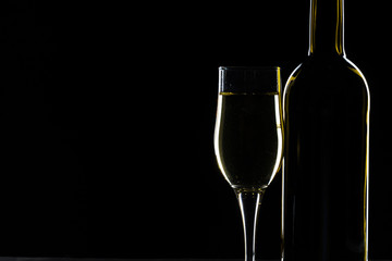  wine bottle and wine glass in a black background