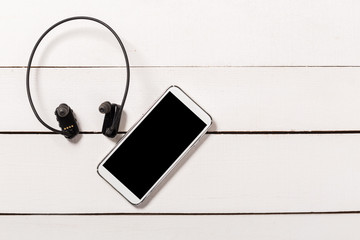 water resistant Headphones with Smartphone on wooden background