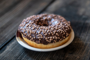 Homemade donuts with chocolate fill and nuts on old wooden table