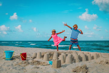 cute boy and girl play with sand on beach vacation