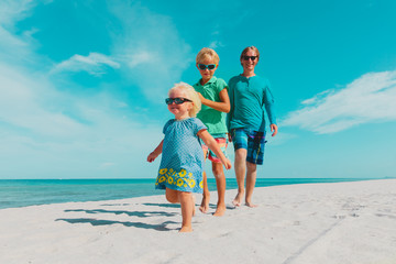 happy father with kids walking on beach