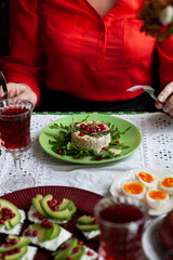 A woman in a red blouse cuts a baked camemberle, in the frame only hands. Healthy nutritious lunch or dinner for two