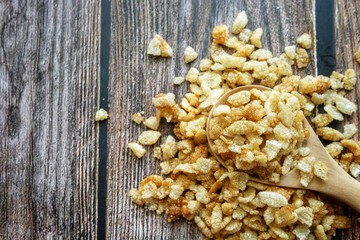 Close up of dried rice snack on wooden spoon.