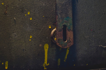 The rusty lock latch hanging on the front of the vintage style toolbox in the shop. 