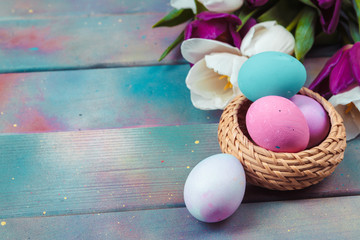 Easter eggs with tulips on blue wooden background
