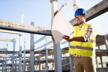 Picture of construction site engineer looking at plan