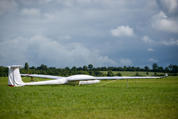 Segelflugzeuge stehen vor dunklen Wolken am Boden 