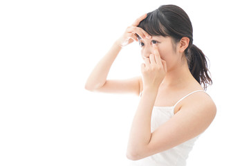 Fototapeta premium コンタクトレンズを装着する若い女性