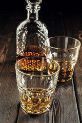 Whiskey glass and bottle on the old wooden table
