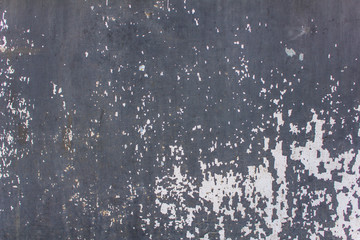 old blue gray concrete wall with white peeling paint and scratches. rough surface texture