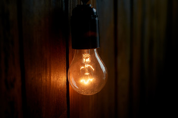 Edison light bulb hanging on a long wire. Cozy warm yellow light. Retro