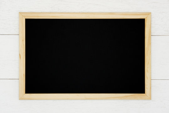 Blank chalkboard on white wood plank background. 