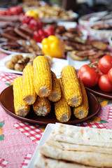 Corn stack on a plate near the tomatoes