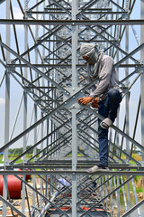 The construction for a billboard made of a large high rise billboard on a super highway in THAILAND telephoto close up on construction detail.