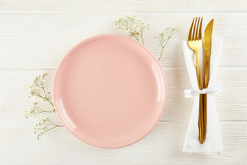 Table setting arrangement in minimal style with easter spring holiday attributes, fork, knife and napkin. Background, copy space, close up, flat lay, top view.