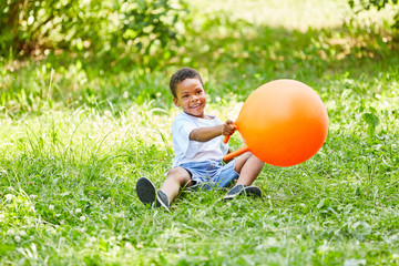 African boy is playing with a hopping ball