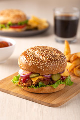 Burger with sliced pickle, onion and fried potatoes	