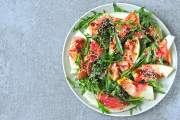 Salad with arugula, melon and prosciutto. Keto diet. Paleo diet. Pegan diet. The concept of a beautiful and delicious diet food.