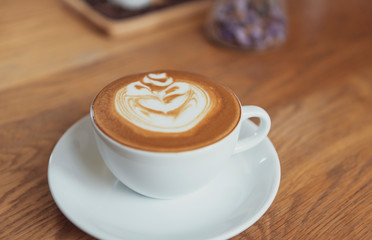 latte or Cappuccino with frothy foam, coffee cup top view on table in cafe.