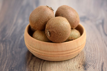 Kiwi fruit in a bowl on wooden background