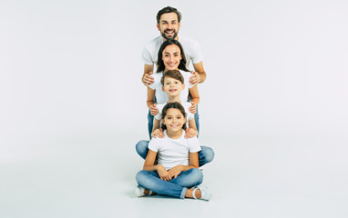 Fototapeta na wymiar Happy cute smiling family looking on camera isolated on white studio