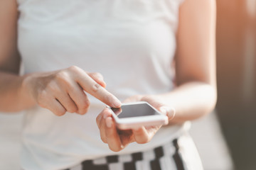 Close up woman hand hold using smart phone on outdoor park street background.
