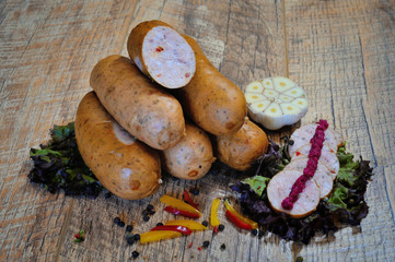 Fresh boiled Wiener sausages with green herbs and vegetables isolated on the white background.