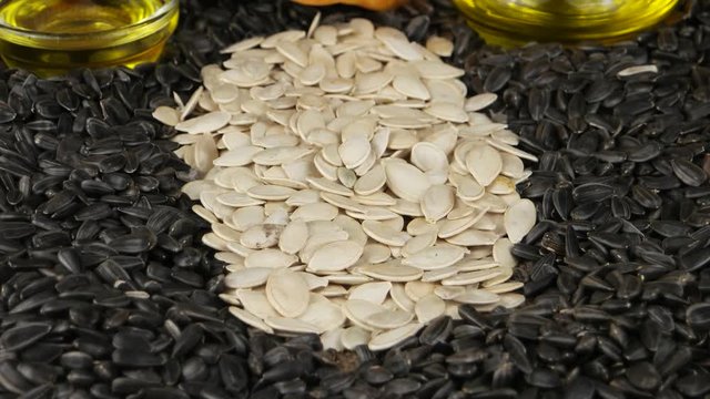 Sunflower oil and pumpkin oil in a glass bottles and a bowl on the background of sunflower and pumpkin seeds 