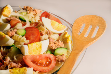 Tuna salad and wooden spoon on white background