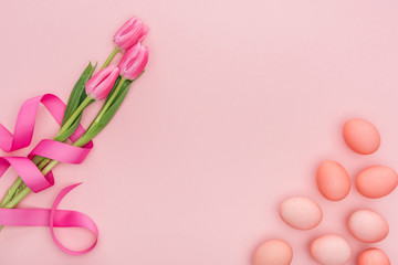 top view of pink tulip flowers and traditional easter eggs isolated on pink