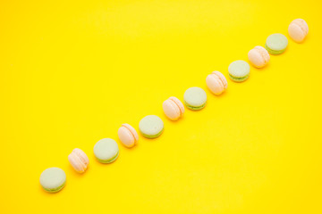 Assorted row of french macaroons over yellow background