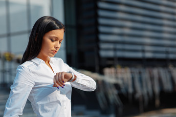 Businesswoman looking at the watch outdoor