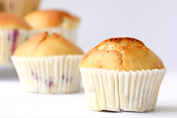 Fresh tasty muffins with berries on white background. Close up. Side view