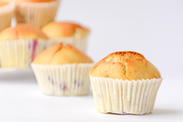 Fresh tasty muffins with berries on white background. Close up. Side view