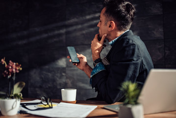 Businessman having coffee brake and using smart phone