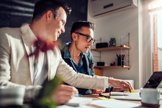 Businessmen Working Together And Using Laptop In The Office